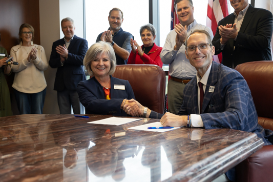 Dr. Robin Hickerson, Texarkana Chamber of Commerce President and CEO and Dr. Ross Alexander, President of Texas A&M University-Texarkana sign documents creating a new partnership between the Chamber of Commerce and the university.