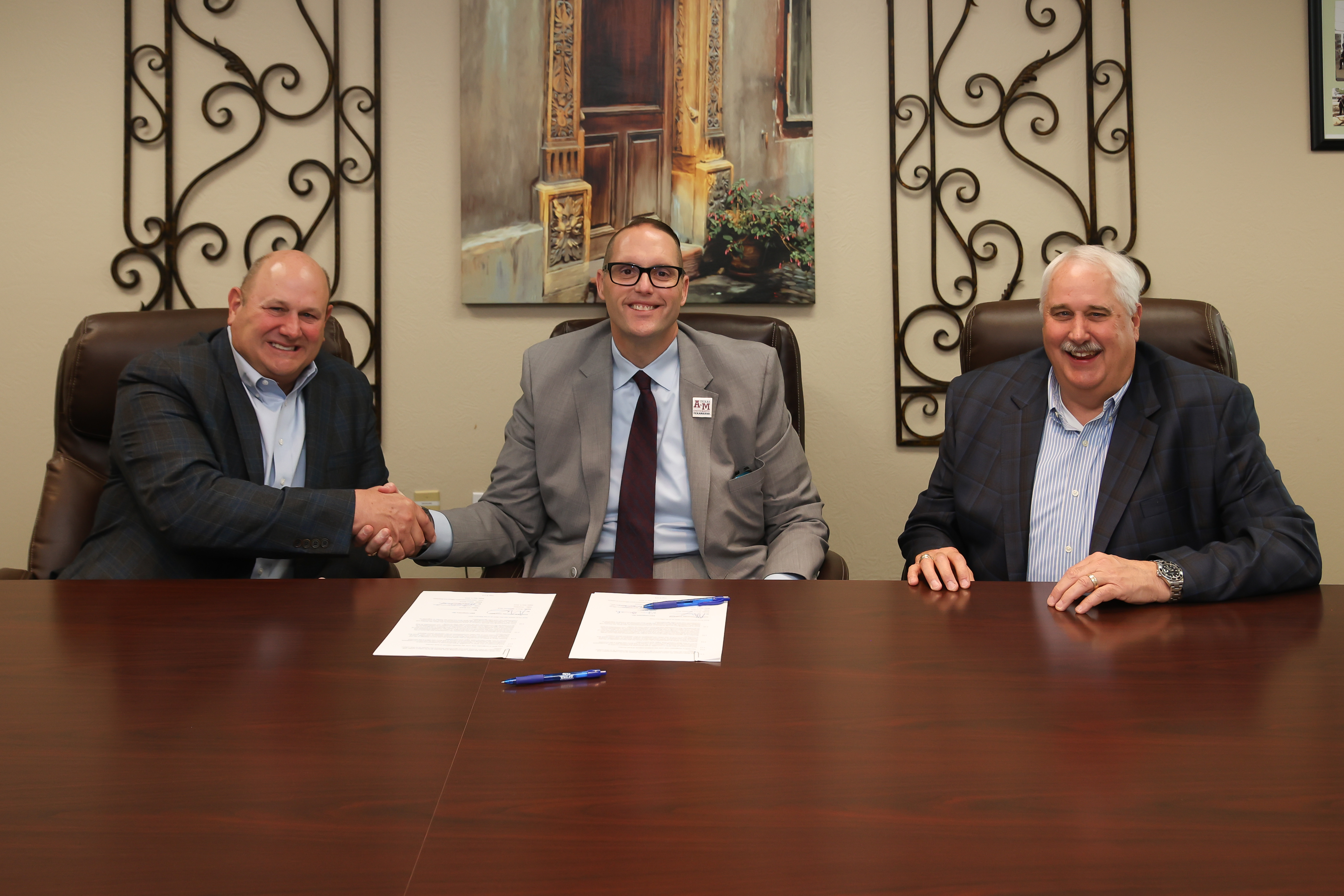 BWI Companies, Inc President and CEO Jim Bunch (left), A&M-Texarkana President Dr. Ross Alexander (center), and BWI Companies, Inc. Co-President and CAO Robert Bunch (right) sign documents establishing an academic partnership between the university and the company.